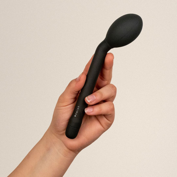 A hand holds a black bsiwsh bgee classic plus vibrator