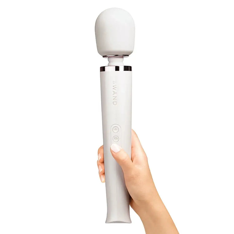 A white Le Wand OG rechargeable massager vibrator is shown in a person&