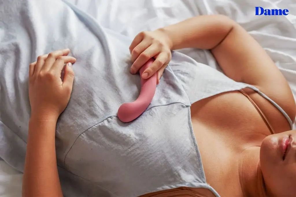 A woman holds arc, the g-spot vibrator against her chest