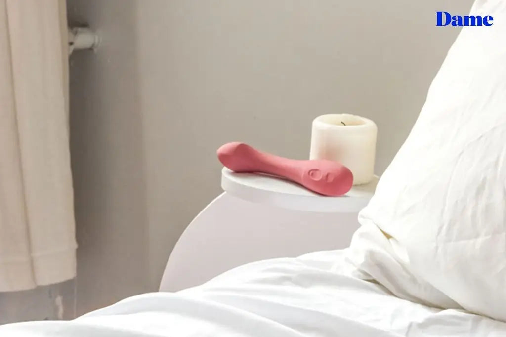 Arc, the G-spot vibrator sits on a bedside table next to a white candle