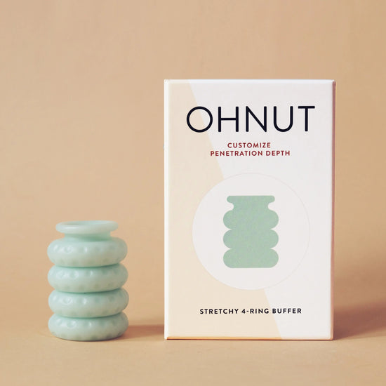 Four Jade Ohnut rings for customizable penetration depth stacked next to package on peach background.